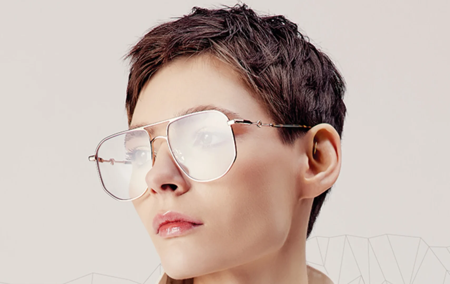 Imagen de una mujer módelo profesional con pelo corto oscuro, maquillaje natural y gafas de montura ligera